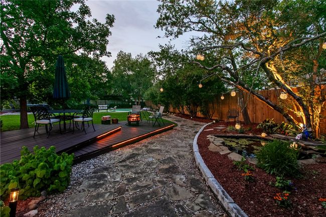 View of home's community with a wooden deck, outdoor dining space, and a fenced backyard | Image 43