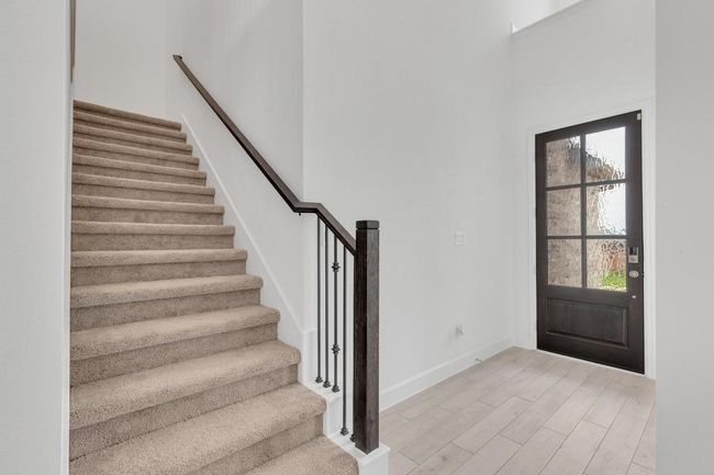 Foyer with light wood finished floors, stairway, and a high ceiling | Image 4
