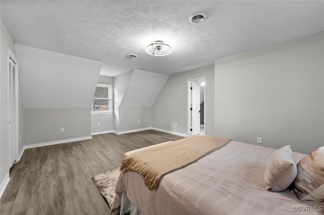 Bedroom with wood finished floors, a textured ceiling, and vaulted ceiling | Image 27