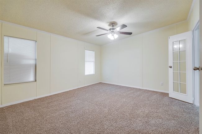 Carpeted empty room with a textured ceiling and a ceiling fan | Image 17
