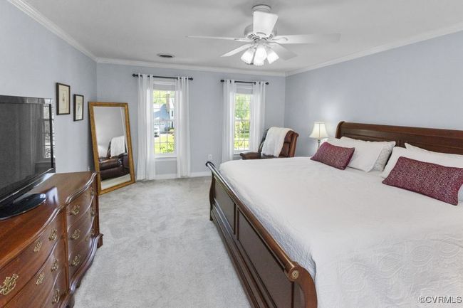 Bedroom with light carpet, crown molding, a ceiling fan, and baseboards | Image 25
