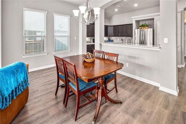 Dining area featuring sink, wood-type flooring, and an inviting chandelier | Image 10