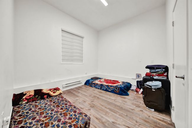 Bedroom featuring wood finished floors, baseboard heating, and vaulted ceiling | Image 14