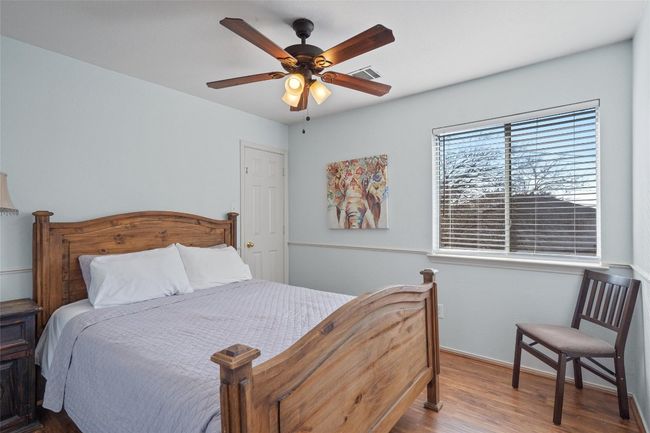 Bedroom with visible vents, ceiling fan, baseboards, and wood finished floors | Image 21