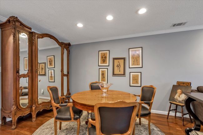 Dining room with visible vents, a textured ceiling, ornamental molding, and wood finished floors | Image 4