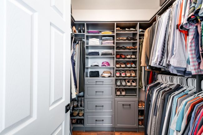 Lovely walk-in closet thoughtfully outfitted with a custom closet system for all your organizational needs! | Image 28