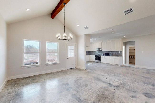 Unfurnished living room with recessed lighting, beamed ceiling, visible vents, and an inviting chandelier | Image 12
