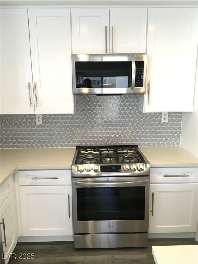 Kitchen featuring white cabinetry, light countertops, and stainless steel range with gas stovetop | Image 8