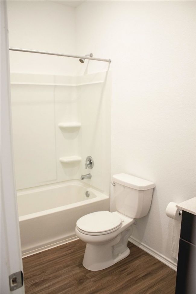 Full bathroom featuring wood finished floors, vanity, and bathtub / shower combination | Image 6
