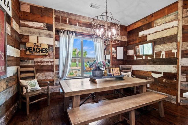 Dining area with wooden walls, wood finished floors, a chandelier, and plenty of natural light | Image 10