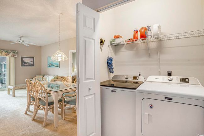 Laundry room featuring independent washer and dryer, ceiling fan, light colored carpet, and baseboards | Image 7
