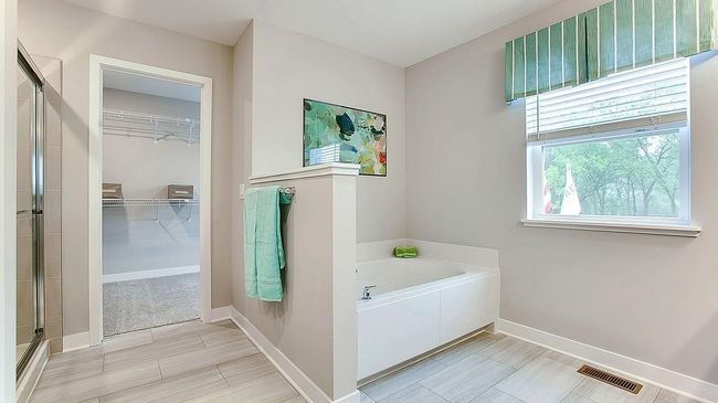 The spa-like primary bathroom is the perfect place to unwind and decompress! Dual sinks, enclosed toilet room, separate shower and soaking tub, and large walk-in closet. | Image 25