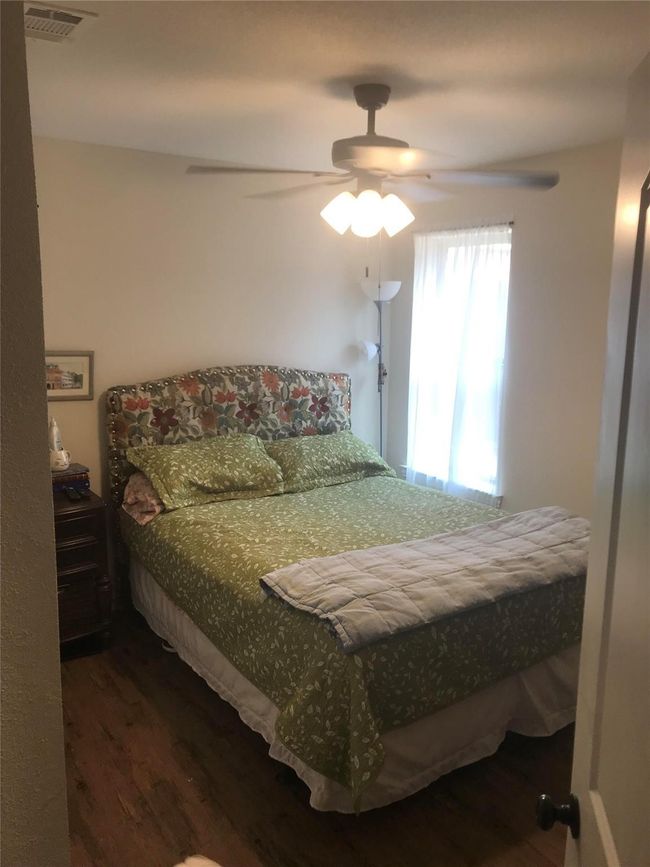 Bedroom featuring wood finished floors and a ceiling fan | Image 4