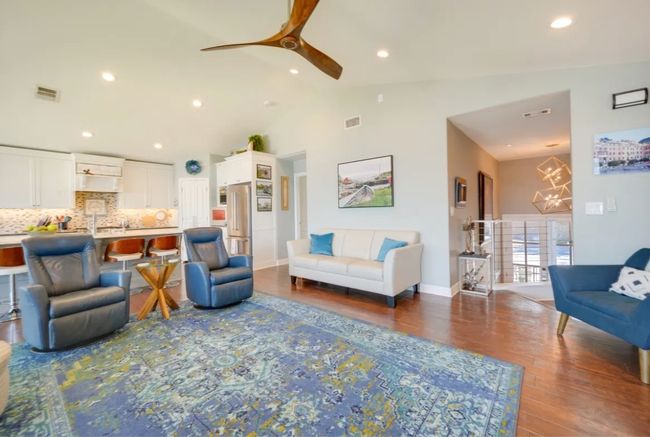 Living area with dark wood-style floors, lofted ceiling, a ceiling fan, recessed lighting, and a chandelier | Image 7