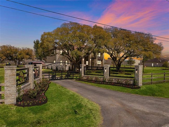 Mature trees and custom gate greet at the entrance to your property. | Image 26