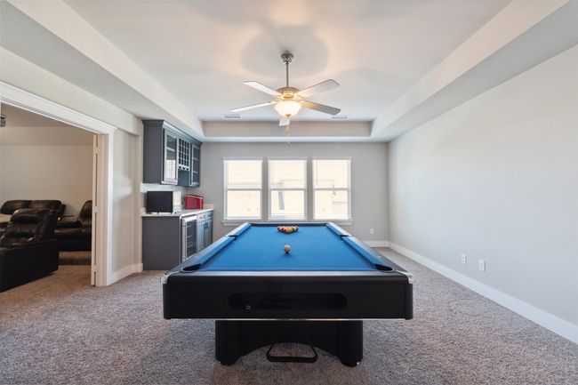 Rec room with carpet, a ceiling fan, pool table, and a raised ceiling | Image 28