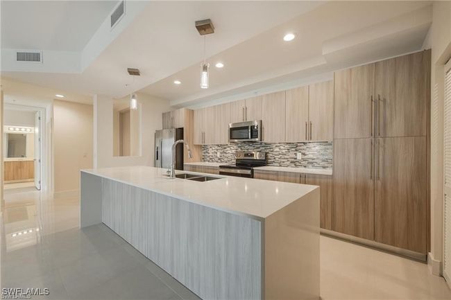 Kitchen with a sink, decorative backsplash, modern cabinets, stainless steel appliances, and visible vents | Image 7