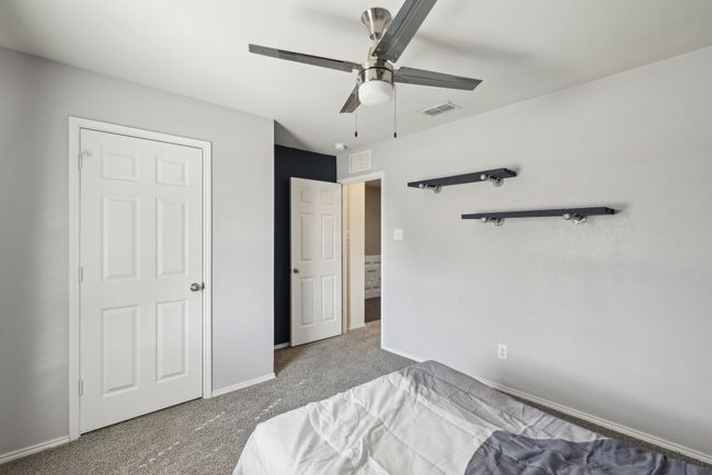Carpeted bedroom with baseboards, ceiling fan, and visible vents | Image 16