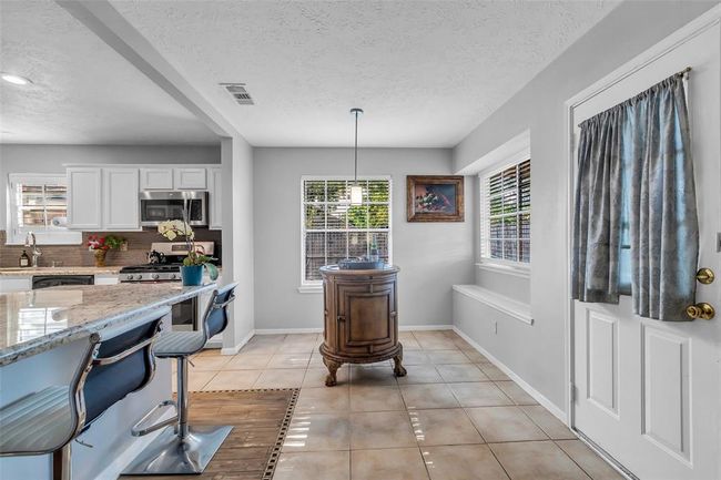 Lovely breakfast area with large windows overlooking the backyard. | Image 21