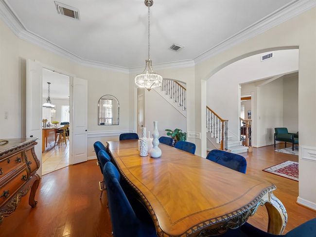 Elegant dining room with classic charm, featuring hardwood floors and a sparkling chandelier—perfect for hosting memorable gatherings. | Image 9