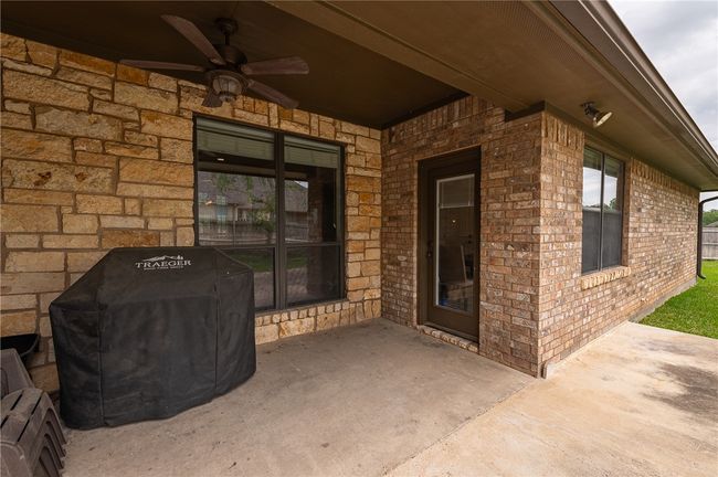 Doorway to property featuring ceiling fan, a patio area, and brick siding | Image 32