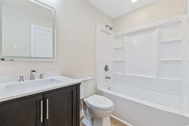 Bathroom with toilet, vanity, bathing tub / shower combination, and wood finished floors | Image 16