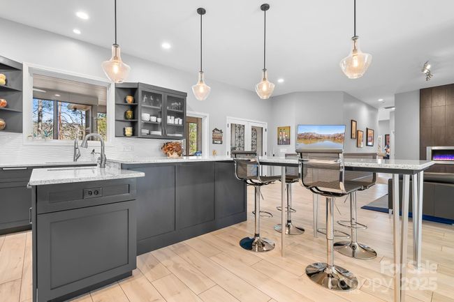Kitchen Island with prep-sink, pendant lights and modern touches. | Image 10