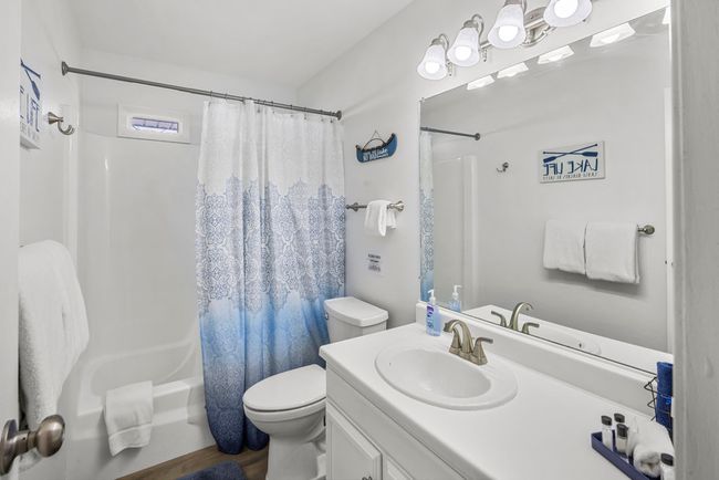 Bathroom featuring shower / bath combo with shower curtain, toilet, and vanity | Image 15