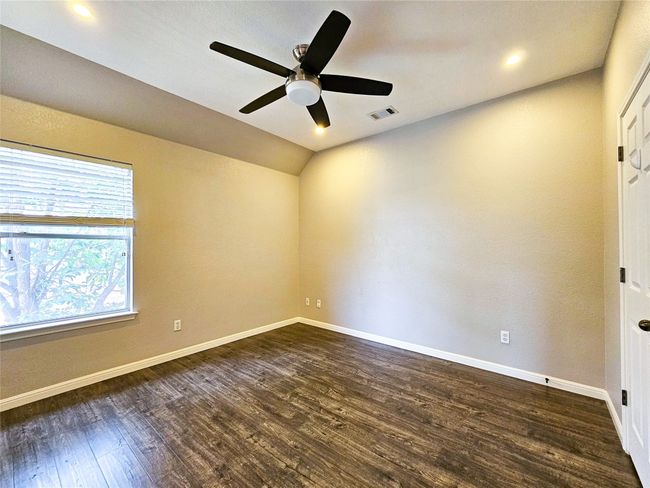 Empty room featuring dark wood finished floors, a ceiling fan, baseboards, lofted ceiling, and recessed lighting | Image 25