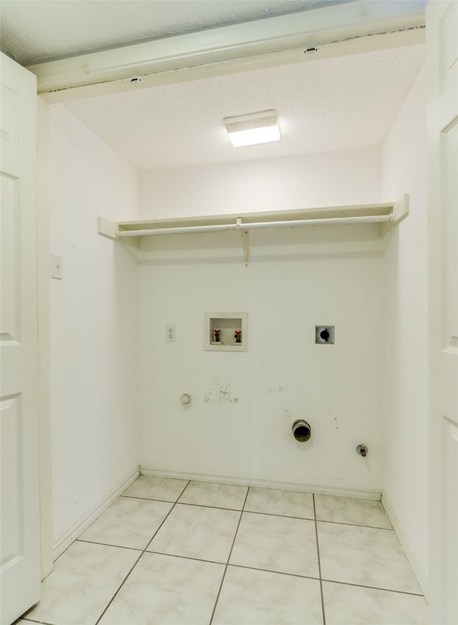 Laundry area featuring laundry area, hookup for an electric dryer, gas dryer hookup, hookup for a washing machine, and light tile patterned flooring | Image 20