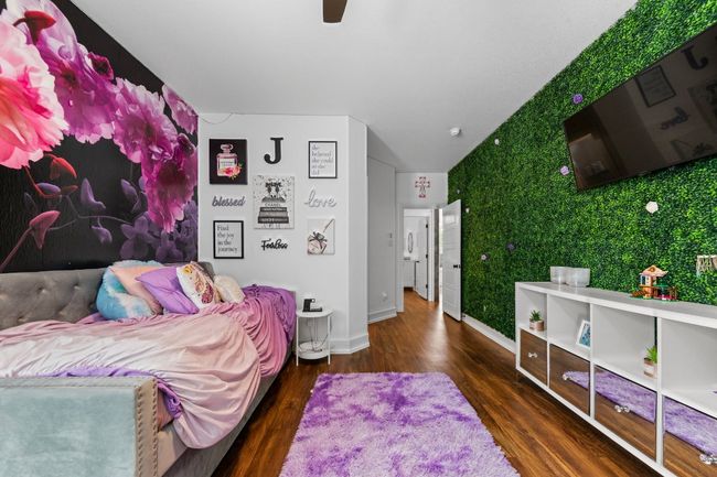 Bedroom featuring wood finished floors, ceiling fan, and baseboards | Image 31