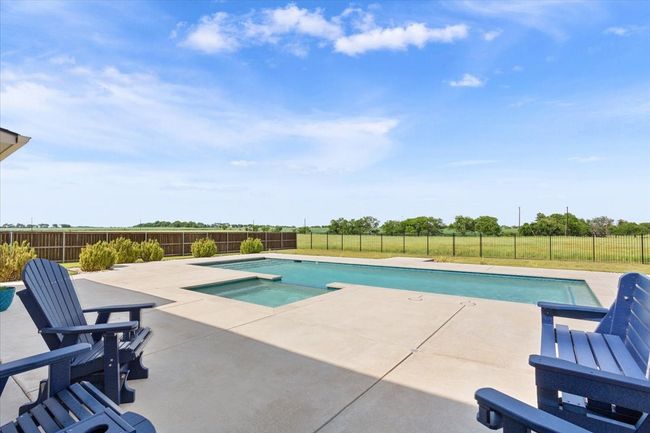 View of swimming pool featuring a patio, a fenced backyard, and a pool with connected hot tub | Image 36
