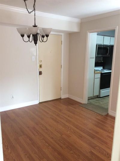 Dining room with front door ahead and kitchen to right. | Image 2