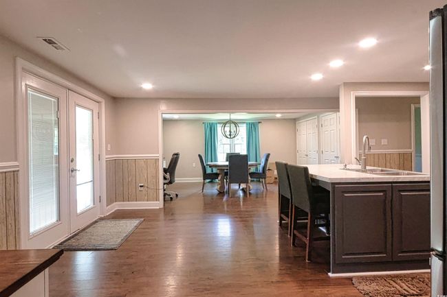 Kitchen featuring french doors, a wainscoted wall, dark wood finished floors, dark brown cabinets, and recessed lighting | Image 16