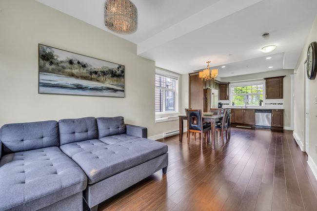Living room with a chandelier, baseboards, dark wood-type flooring, and recessed lighting | Image 6