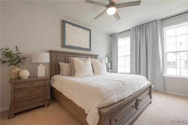 Bedroom with light carpet, baseboards, and multiple windows | Image 30