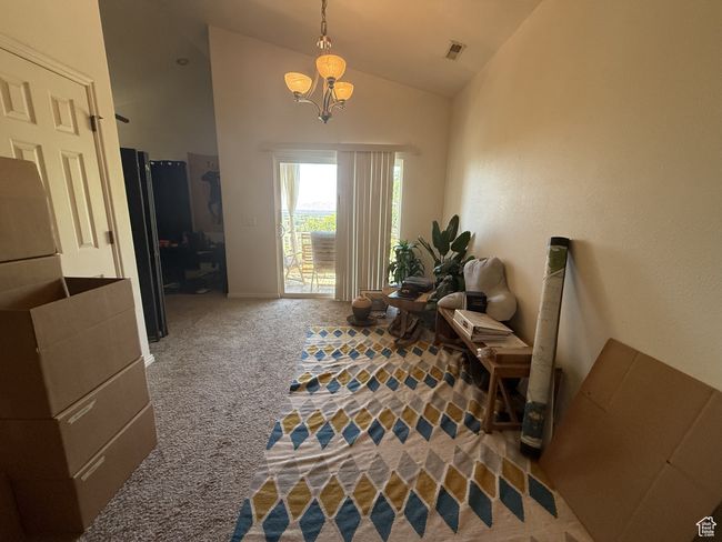 Dining area with carpet, lofted ceiling, and a chandelier | Image 8