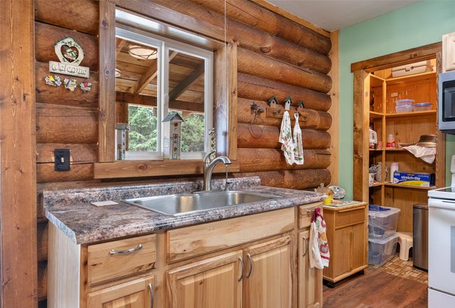 Kitchen with rustic walls, white electric range, stainless steel microwave, and dark wood finished floors | Image 37