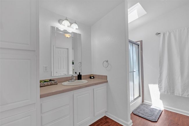 Full bath with a skylight, wood finished floors, vanity, and a shower with door | Image 18