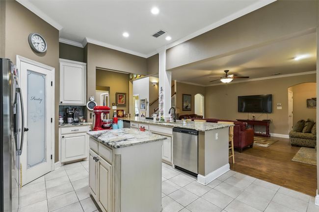 Kitchen with appliances with stainless steel finishes, open floor plan, arched walkways, ceiling fan, and ornamental molding | Image 13