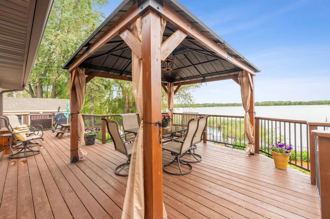 Expansive deck overlooking the spacious patio and lake | Image 36