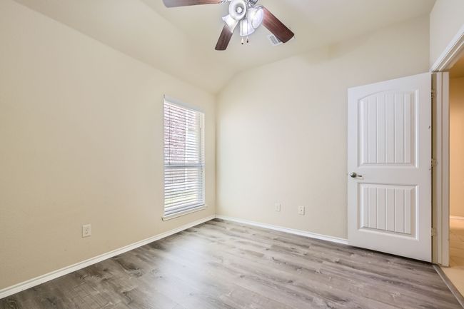 Unfurnished room with wood finished floors, ceiling fan, and vaulted ceiling | Image 24