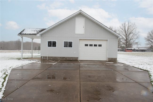 View of side of property featuring an outbuilding, a garage, and concrete driveway | Image 24
