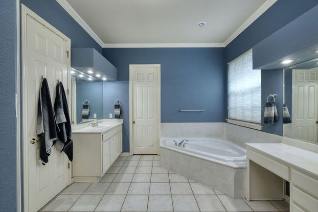 Full bath featuring a bath, crown molding, vanity, and tile patterned floors | Image 17