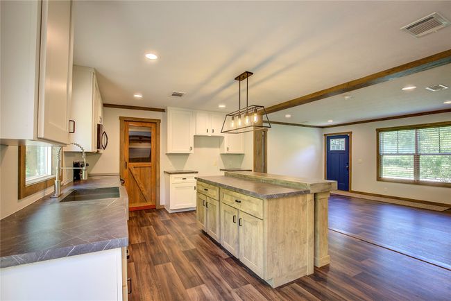 Kitchen featuring dark countertops, recessed lighting, ornamental molding, dark wood-style flooring, and stainless steel microwave | Image 14