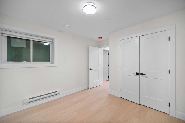 Unfurnished bedroom with a baseboard heating unit, light wood-style floors, and a closet | Image 22