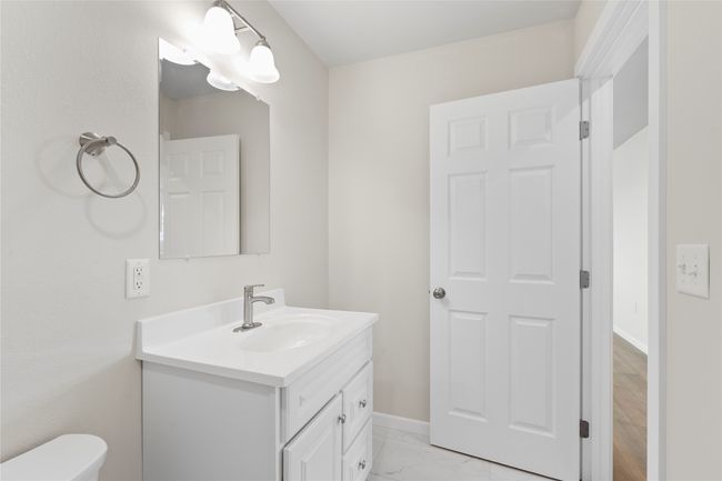 Half bath featuring baseboards, marble finish floor, toilet, and vanity | Image 43