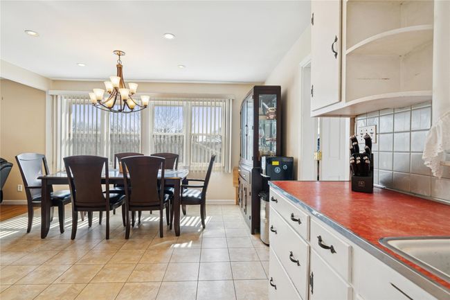 Dining space with light tile patterned flooring, recessed lighting, baseboards, and a chandelier | Image 23