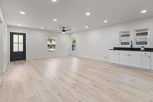 Unfurnished living room with a sink, a ceiling fan, recessed lighting, light wood-style flooring, and baseboards | Image 6