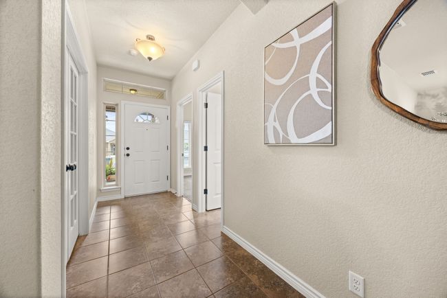 Foyer featuring tile patterned floors and a textured wall | Image 4
